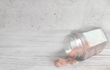 Himalayan pink salt in a glass jar of visipan on the table. Light background