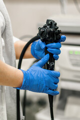 Close-up of doctor's gloved hand with endoscope during diagnostic gastroscopy or colonoscopy in...