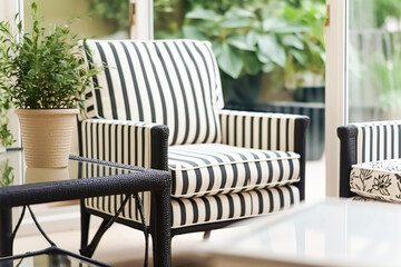 Modern elegant garden furniture with striped pattern in the conservatory in the countryside house. Generative AI