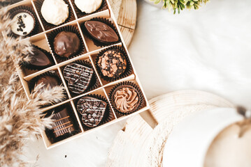 White coffee and chocolate candies on white background indoors