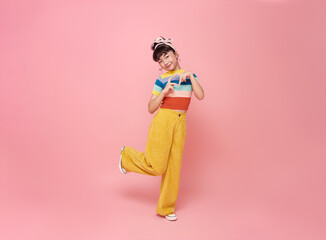 Cheerful Asian child girl celebrate with making mini heart looking at camera isolated on pink background.