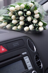A huge bouquet of painful tulips in the car. Vertical picture close up