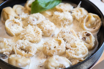 Ravioli in black plate on restaurant counter near window