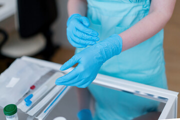 a gynecologist putting on rubber gloves prepares to examine a patient in a gynecology clinic close-up