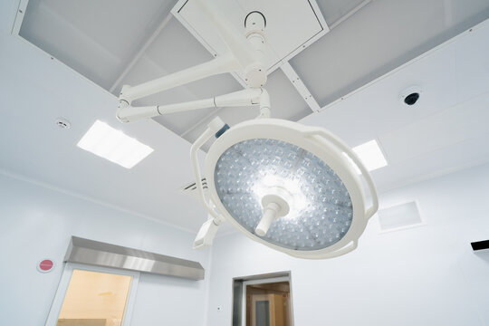 Big round modern lamps on the surgery room ceiling Advanced illumination equipment for surgeries in present day clinics