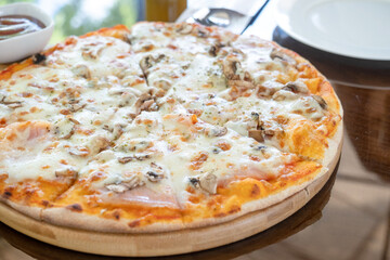 italian chicken pizza with mozarella cheese on glass table in street cafe