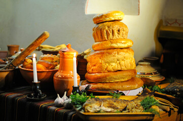 Traditional Ukrainian food on Christmas Eve: ewer with kutia , fried fish, garlic and bread placed near rustic oven. Kyiv, Ukraine