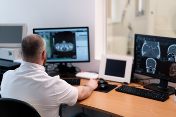 Fototapeta na wymiar the patient undergoes computed tomography in the clinic the radiologist monitors the procedure and the results of the scan