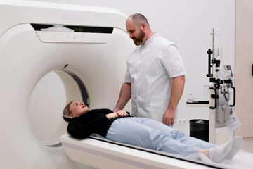 A radiologist performs a computer tomography procedure in a medical clinic A head examination is...