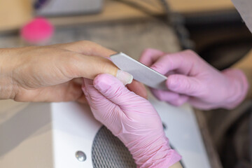 Nails manicure detail with file or brush item. Woman beautiful nail care process.