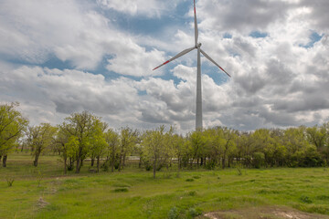 Fototapeta premium Wind turbines on the background of a summer landscape with blue sky, white clouds