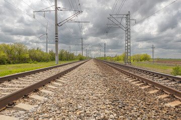 in spring, the railway tracks go into the distance, blue sky with white clouds