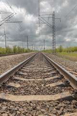 in spring, the railway tracks go into the distance, blue sky with white clouds