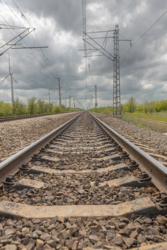 in spring, the railway tracks go into the distance, blue sky with white clouds