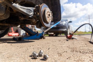 Car on tire mounting with removed wheel on pneumatic jack, seasonal tire change, car service...