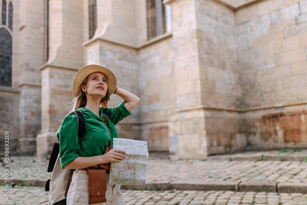 Wall mural young woman travel alone in old city centre. wide photography.