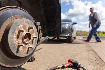 Car on tire mounting with removed wheel on pneumatic jack, seasonal tire change, car service...