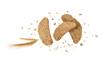 Cutting slices of wheat rye bread with crumbs and spikelets flying isolated on white background.