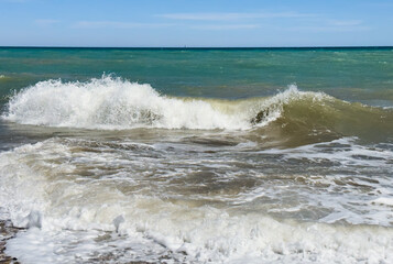 Waves in sea at Beach shore. Waves at sea during storm and wind. Wave from the sea goes on land to the beach. Splashing Waves in ocean, background, texture. Wave at Rising Storm. Sea wave in ocean.