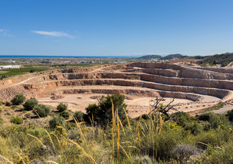 Open pit mining in Spain, Xilxes mountains. Chalk and Dolomite development in quarry. Mining clay in quarry. Anthropogenic landscape in open cast mine. Limestone mining. Lime and plaster mining.