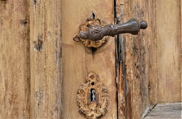 Old wooden door with metal knob and ornaments