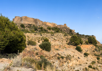 View of Sagunto Castle. Ruins walls of the Fortress Castle at the town of Sagunto, near Valencia in Spain.  Fortress Castillo in Mountains hills. Fort on mountain.
