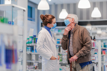 Obraz premium Young pharmacist helping senior man to choos medication.