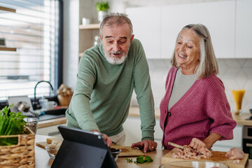 Senior couple cooking together in their kitchen.