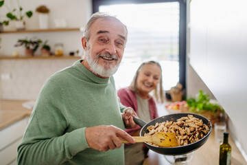 Senior couple cooking together in their kitchen.