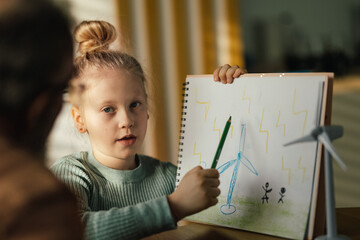 Little girl showing her image and explaining how working wind energy.