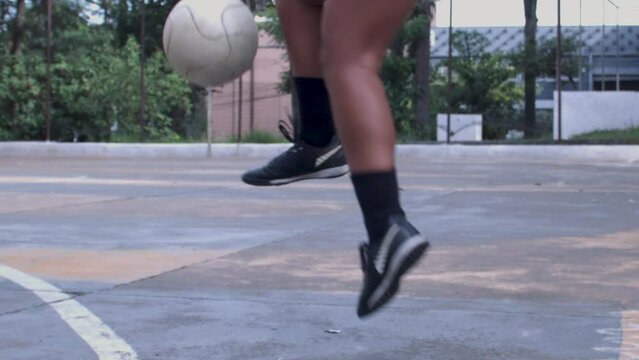 Atleta mulher de futebol feminino chutando brincando bola profissional black brazil afro