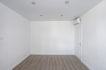 Empty room without furniture with white walls and ceiling, door and air conditioner