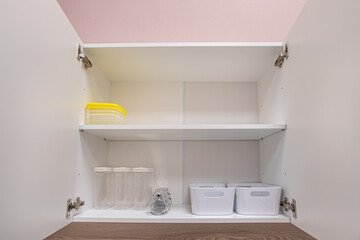 open clean white cupboard in the kitchen, storage organization