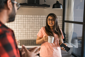 Indian woman talking to latino man in the kitchen. Lifestyle, healthy eating, multi ethnic concept.