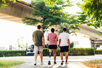 Friend support Friend with a prosthetic leg while exercising outdoor. People walking together on park outdoor. Exercise walking  woman with prosthetic leg and friend support together in  park outdoor