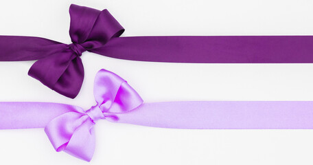 Nœuds de rubans de satin pour paquet cadeau de couleurs violet et rose, isolé sur du fond blanc. Arrière-plan avec nœud en ruban sur fond blanc.	