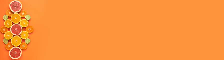 Fresh, Fruity and juicy fruit concept with free text space, web banner. Flat layout with various fresh cut citrus fruits on the left side of the picture on an orange background