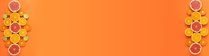 Fresh, Fruity and juicy fruit concept with free text space, web banner. Flat layout with various fresh cut citrus fruits on the left and right side of the picture on an orange background