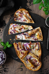 	
Homemade tarte flambee or Flammkuchen with white asparagus, sour cream , red onion and bacon on a...