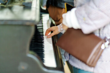 Hands of a woman playing a street piano