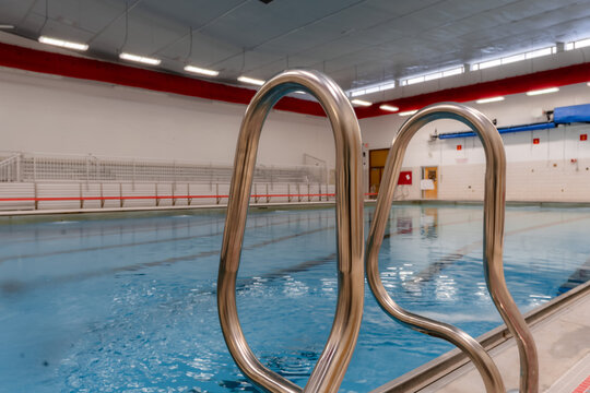 Stainless steel natatorium / swimming pool ladder with hand rails at in inside public swimming pool.