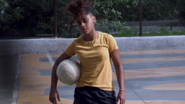 Adolescente de futebol feminino segurando bola e olhando para camera brazil afro