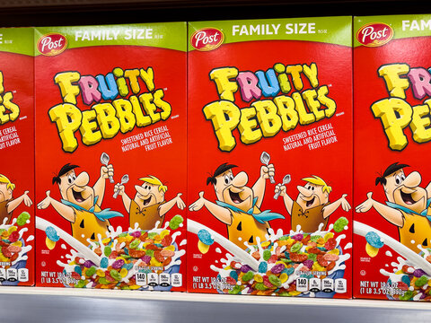 ATLANTA, GEORGIA - MAY 2, 2023 : Boxes of Post Fruity Pebbles breakfast cereal on local grocery store supermarket shelf. Fred Flintstone and Barney Rubble on kids cereal box.