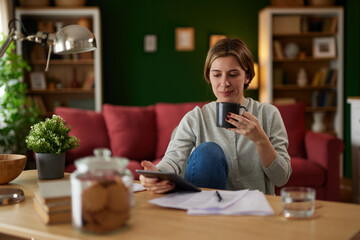 Women using digital tablet to check her finances at home office