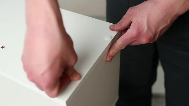Furniture assembler closes euro screws on furniture with plugs, close-up. Furniture assembly. Generative AI