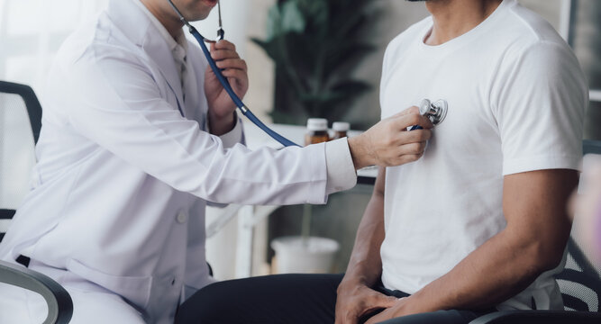 Doctor use stethoscope, checking up heart beat, auscultation in doctor office at hospital. Patient worker has to get medical checkup every year for her health or