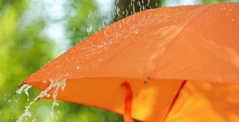 Open umbrella under falling rain drops outdoors, closeup
