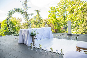 A beautiful wedding ceremony with flowers on the terrace at sunset