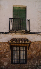 Fototapeta na wymiar Overhanging window and balcony with blinds in a town house