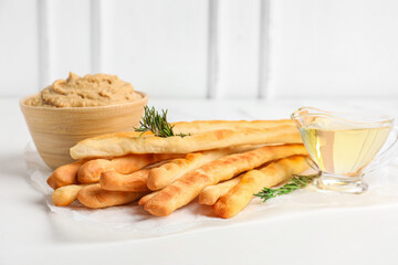 Bowl with tasty hummus and Italian Grissini on table